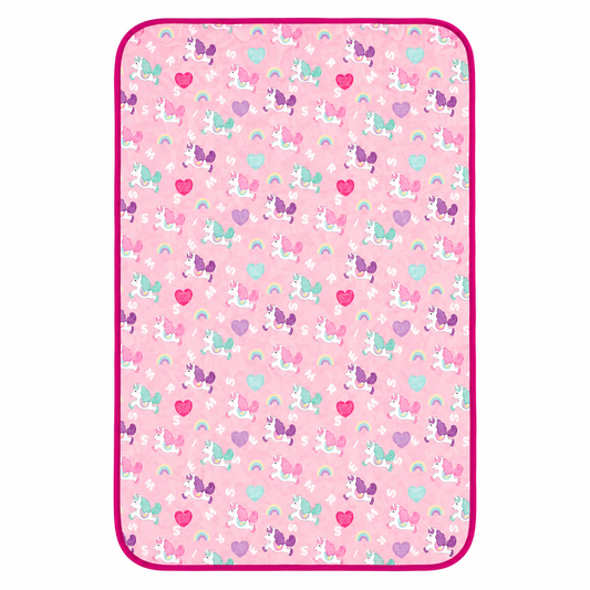 A rectangular pink blanket or mat with rounded corners, featuring a repeating pattern of cartoon unicorns, hearts, and rainbows, finished with a bright magenta border.