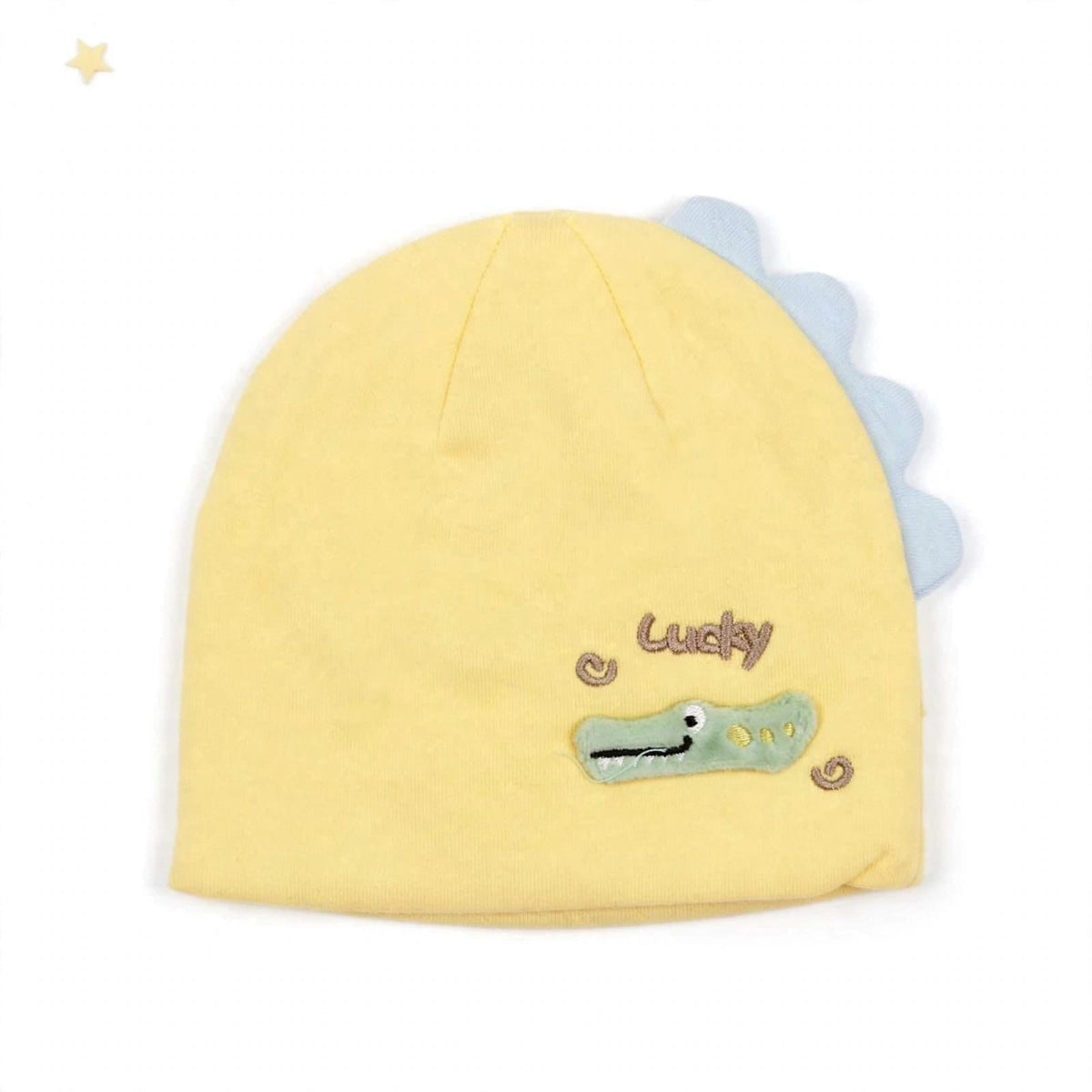A pale yellow knit baby hat featuring a light blue scalloped dinosaur tail and an embroidered green crocodile face with the word 'Lucky' in brown script.